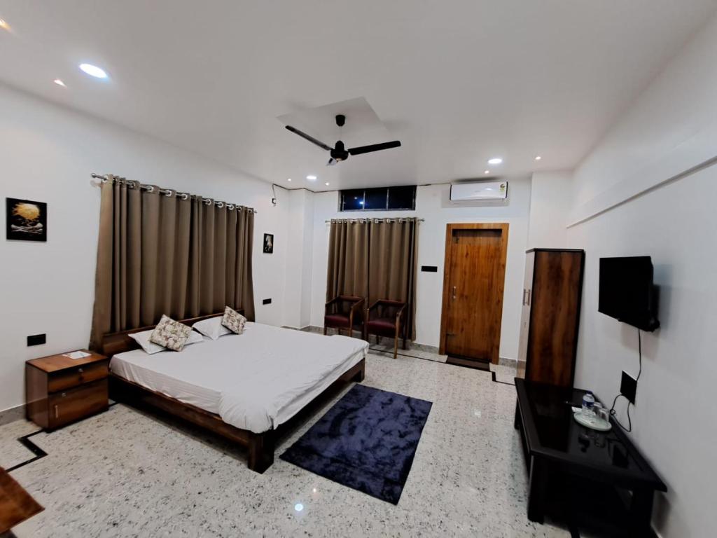 a bedroom with a bed and a television in it at Uttam Hotel & Restaurant in Guwahati