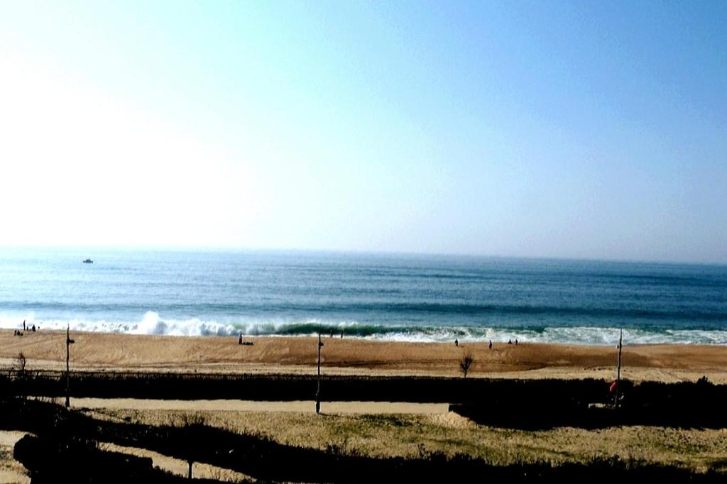 - une plage avec des personnes se promenant sur le sable et l'océan dans l'établissement Beach front apartment in Hossegor, à Hossegor
