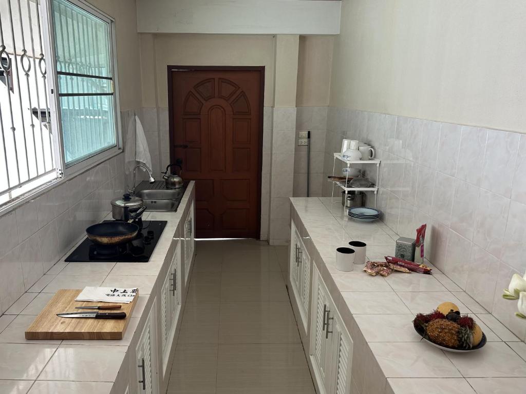 a kitchen with a stove and a sink and a door at Yoga Bed and Breakfast in Chiang Mai