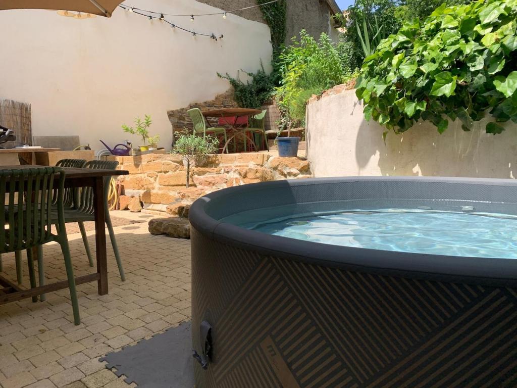 - un bain à remous sur une terrasse avec une table et des chaises dans l'établissement Maison de charme, City center, green setting, à Lyon