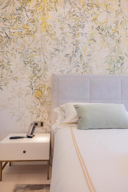 a bedroom with a bed and a table with a phone at Hotel Belvedere in Forte dei Marmi
