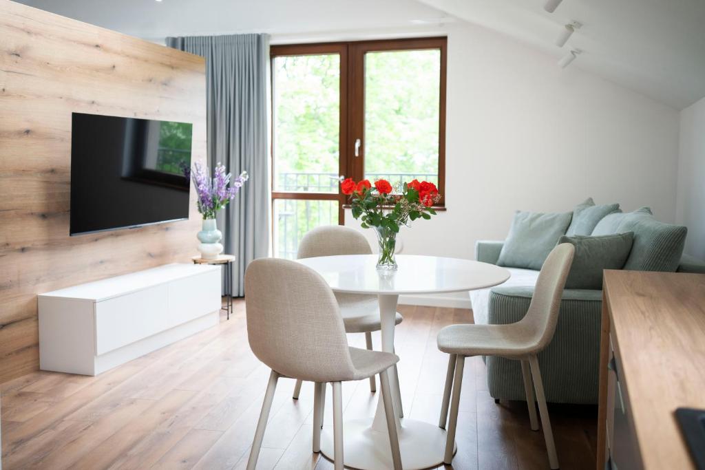 a living room with a table and a couch at Willa Matejki - Apartament 8b in Przemyśl