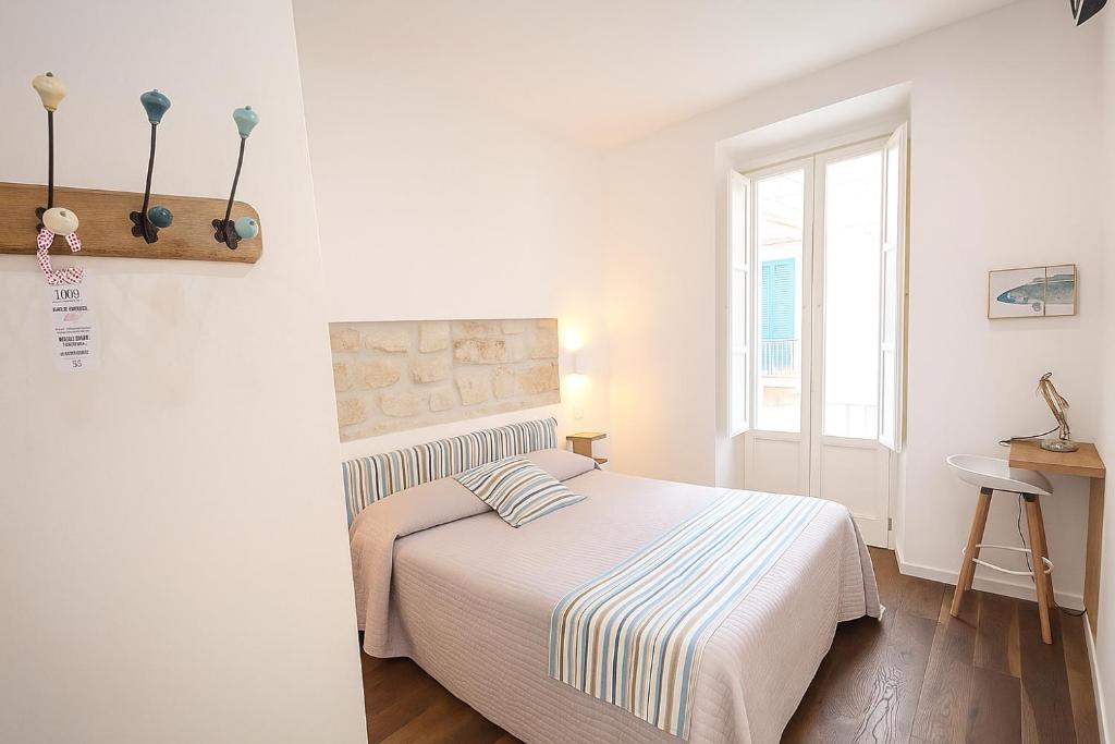 a white bedroom with a bed and a window at B&B 106 Maison de Charme in Mola di Bari