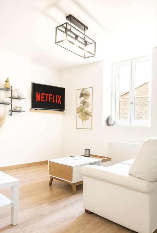 un salon blanc avec un canapé et une table dans l'établissement Le Mans'ardé, au Mans