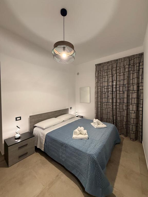 a bedroom with a blue bed and a light fixture at Casa Vacanze - Uliveto in Sciacca