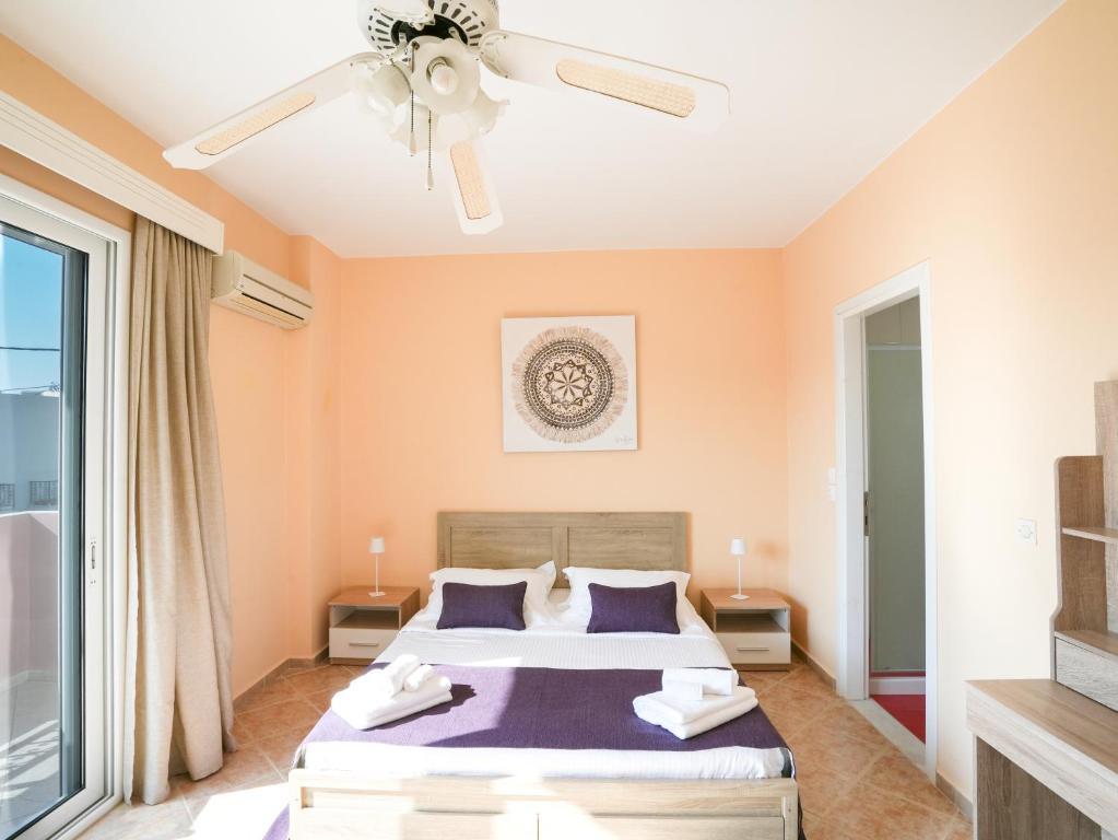 a bedroom with a bed and a ceiling fan at Patrikon House in Kardamaina