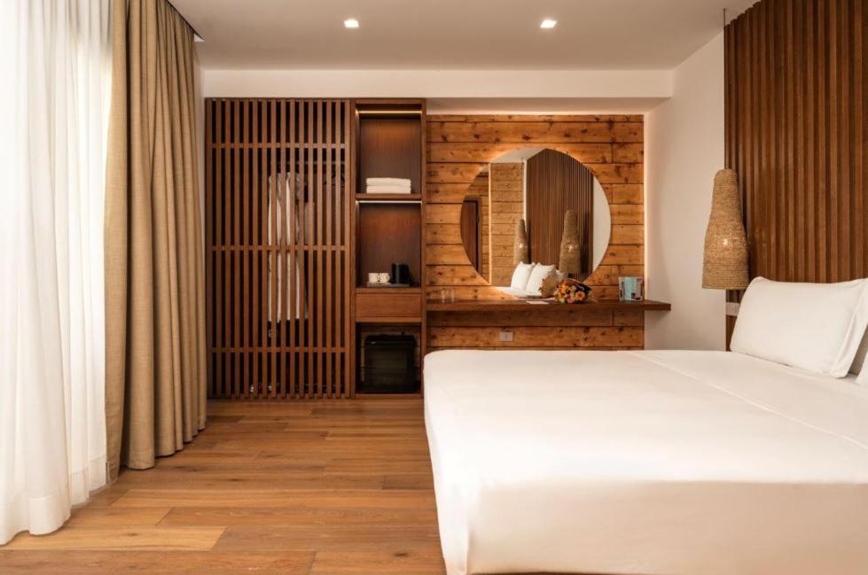 a bedroom with a white bed and a mirror at Nabi Resort Glamping & SPA in Castel Volturno
