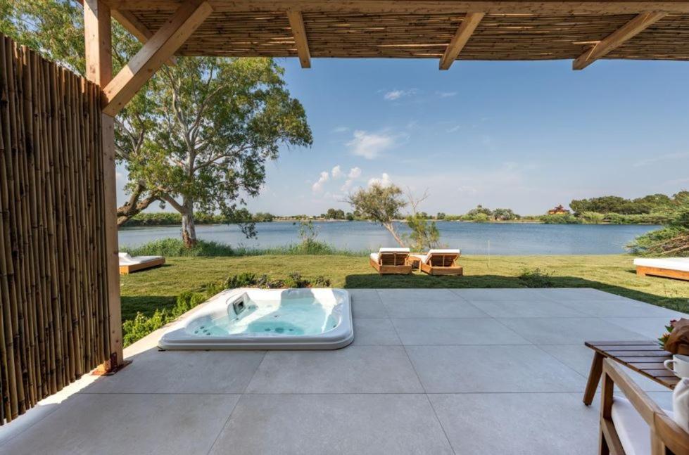 a hot tub on a patio with a view of a lake at Nabi Resort Glamping & SPA in Castel Volturno