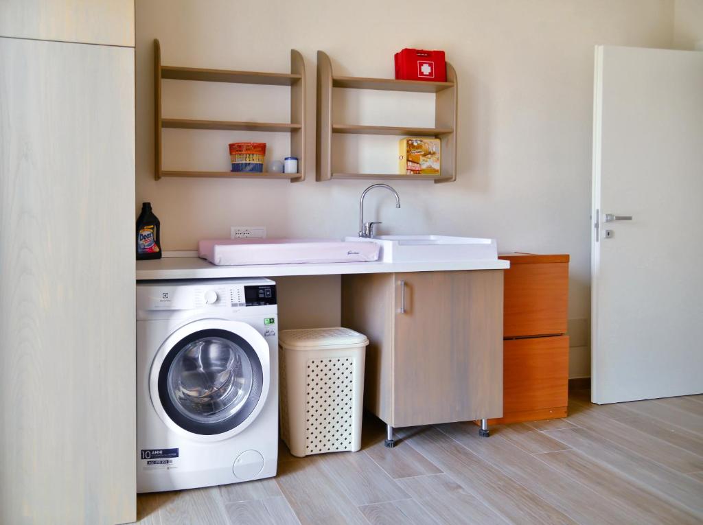 a kitchen with a washing machine and a sink at Il Giardino di Eva - Holiday Home - intero alloggio in Solferino