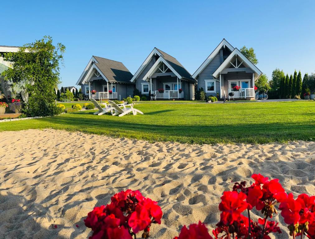 dom na plaży z czerwonymi kwiatami na piasku w obiekcie Mała Finlandia - luksusowe domki w Sarbinowie w Sarbinowie