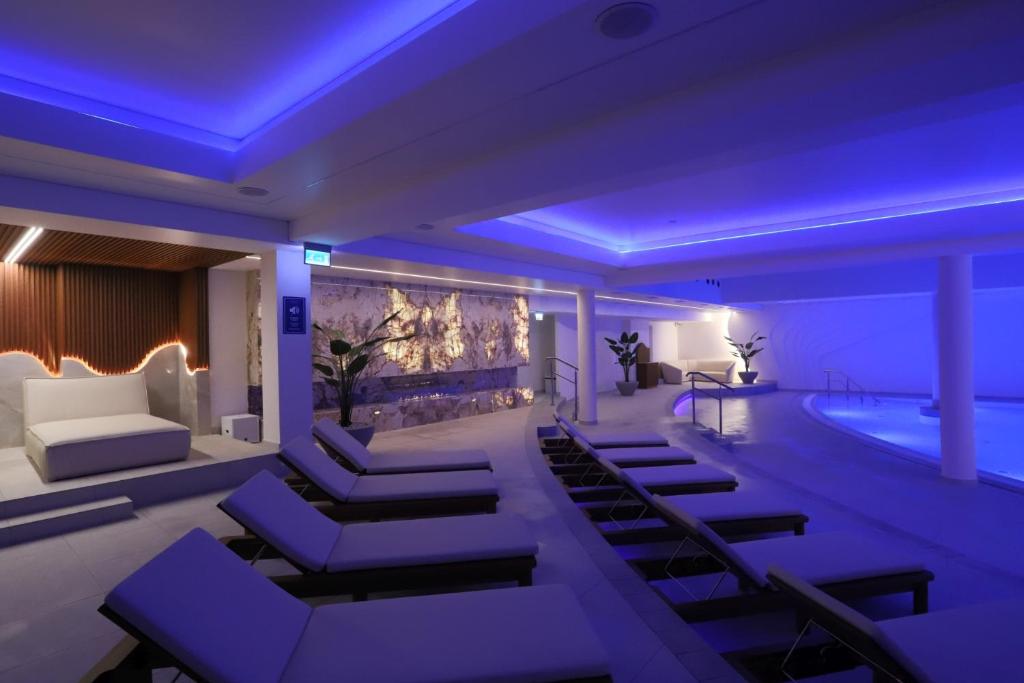 a room with a swimming pool and a room with purple lighting at Grand Lubicz Uzdrowisko Ustka in Ustka