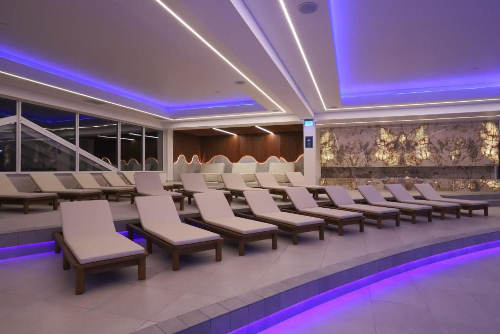 a conference room with white chairs and purple lighting at Grand Lubicz Uzdrowisko Ustka in Ustka