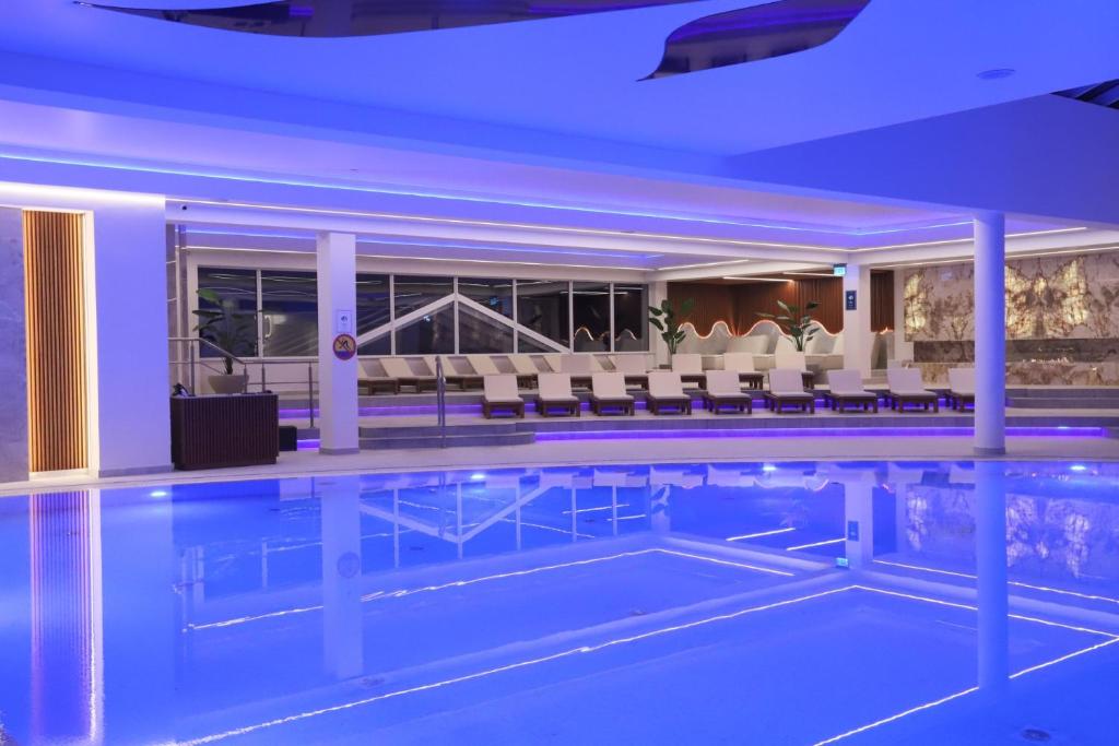 a pool in a hotel with chairs and tables at Grand Lubicz Uzdrowisko Ustka in Ustka