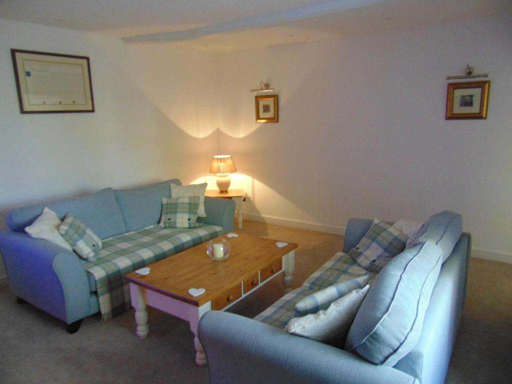 a living room with two blue couches and a coffee table at The Dotterry in Hill Top