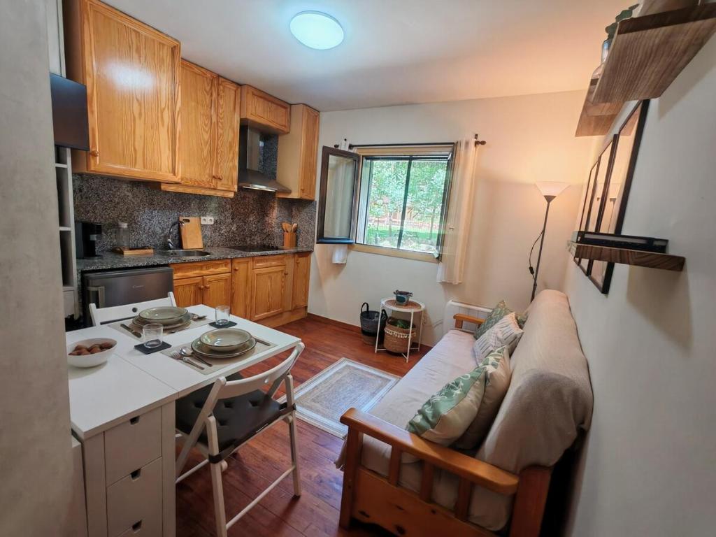 a kitchen with a couch and a table in a room at Tu refugio cómodo y con piscina - Herbasabina 2 in Pla de l'Ermita