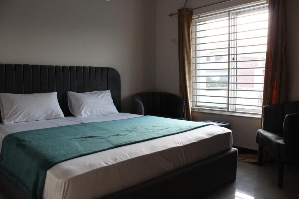 a bedroom with a large bed and a window at Capital Pearl Guest House in Islamabad