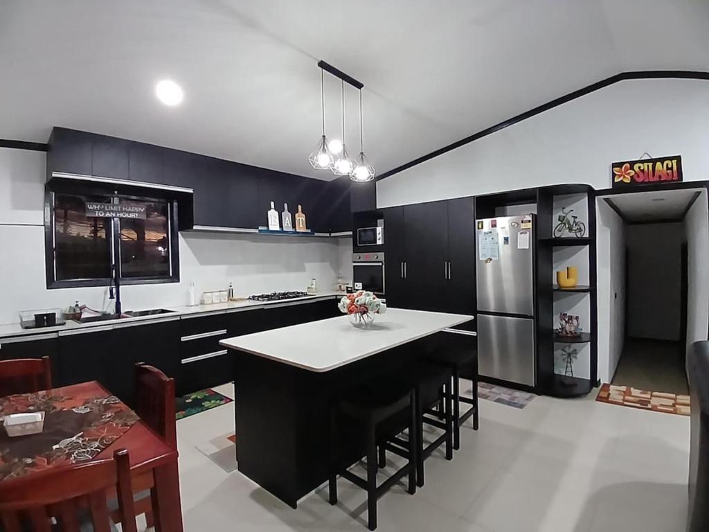 a kitchen with a refrigerator and a table with chairs at Silagi Holiday Home in Nadi