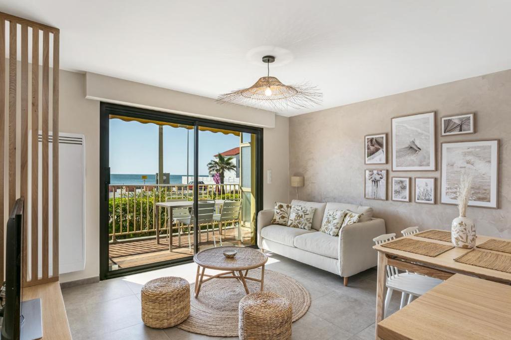 un salon avec un canapé et une table dans l'établissement appartement face à la mer avec parking, à Palavas-les-Flots