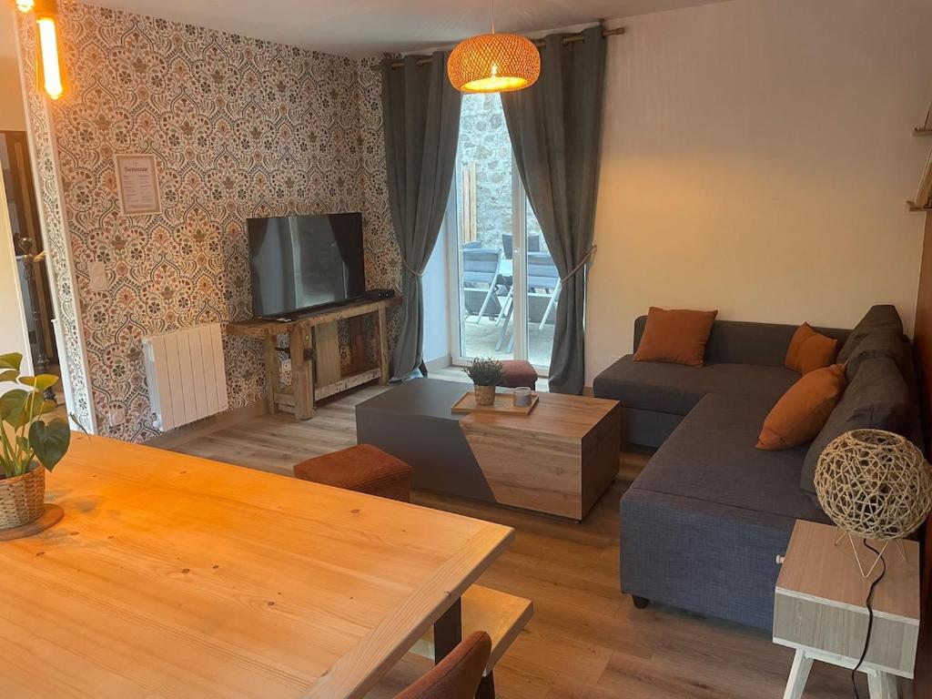 a living room with a couch and a table at La Maison Du Pavé in Villedieu-les-Poëles