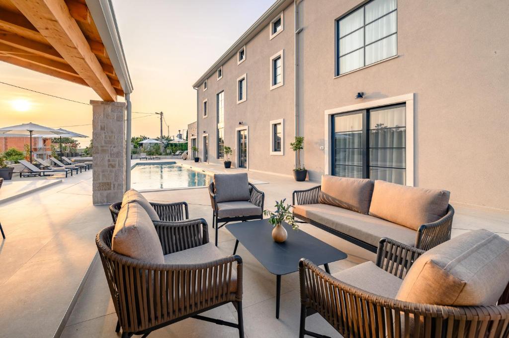 a patio with couches and chairs and a pool at Luxury Villa Madora with pool in Porec, Istria in Krmenjak