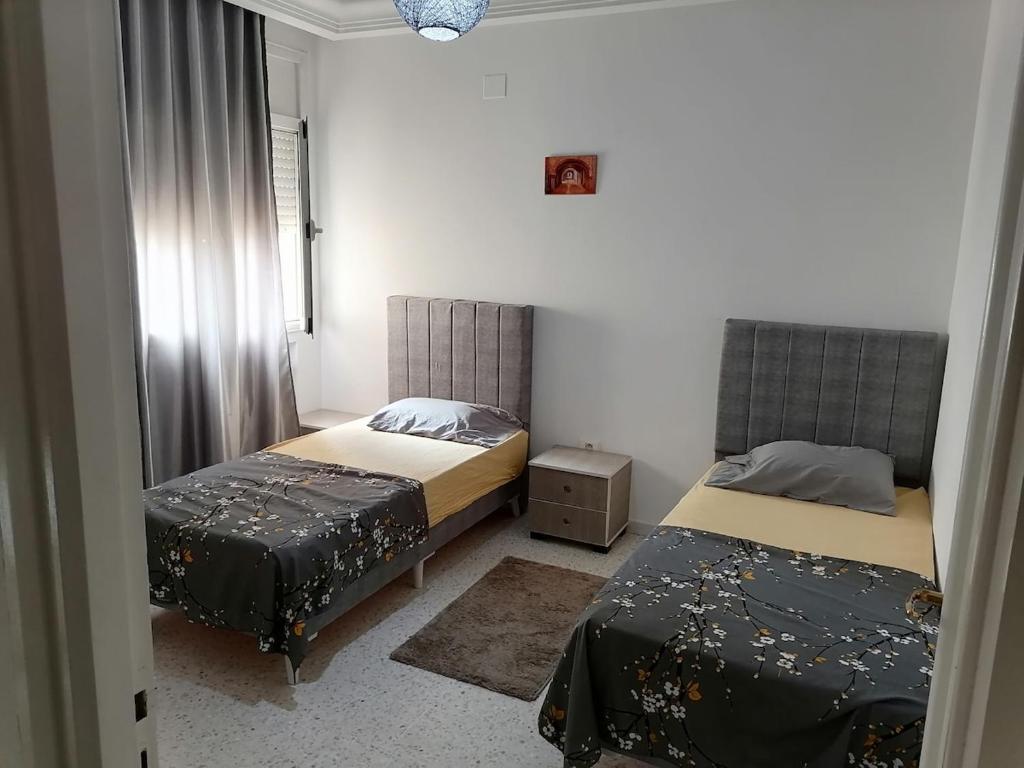 a bedroom with two beds and a window at Le bon sejour in El Aouina Station
