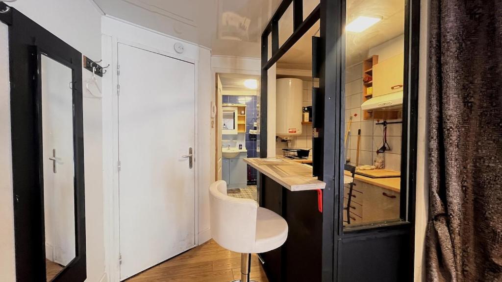 une petite cuisine avec un comptoir blanc et un tabouret blanc dans l'établissement Petit studio en centre ville, à Clermont-Ferrand