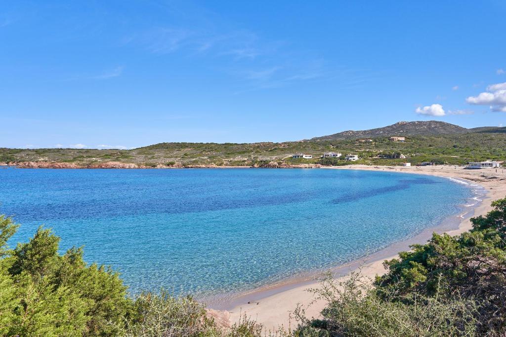 Blick auf einen Strand mit blauem Wasser in der Unterkunft Affittimoderni Isola Rossa Borgo - Ulivi 9 in Isola Rossa