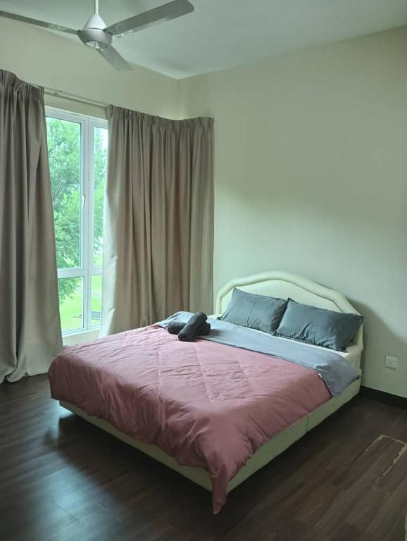 Un dormitorio con una cama grande con sábanas moradas y una ventana. en IJM Sri Utama Condo, en Sandakan