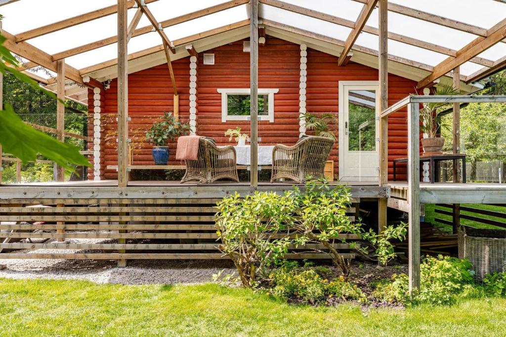 a wooden cabin with a table and chairs on the porch at Log Cabin by Nuuksio National Park, Espoo in Espoo