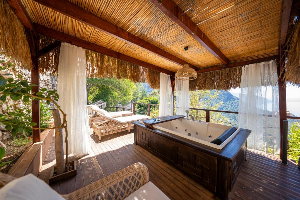 a large room with a bath tub on a deck at Lissiya Hotel in Faralya