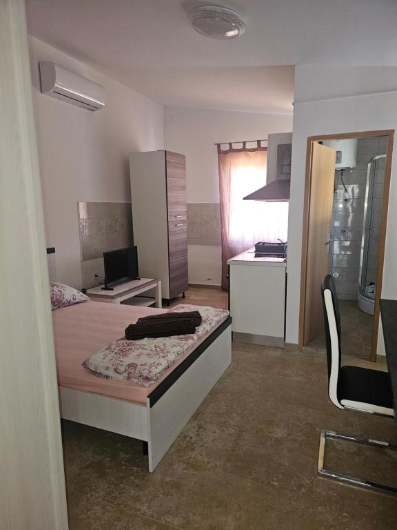 a small bedroom with a bed and a kitchen at Villa Marko 1 Bedroom apartment-Studio 4 in Pula