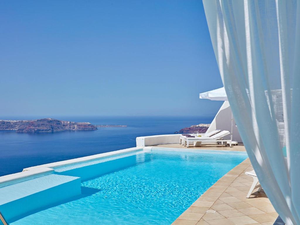 a swimming pool with a view of the ocean at Astra Suites in Imerovigli
