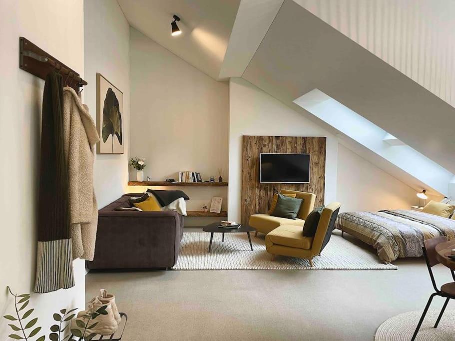 a living room with a bed and a couch at Stilvolles Loft mit Naturpool in Mels
