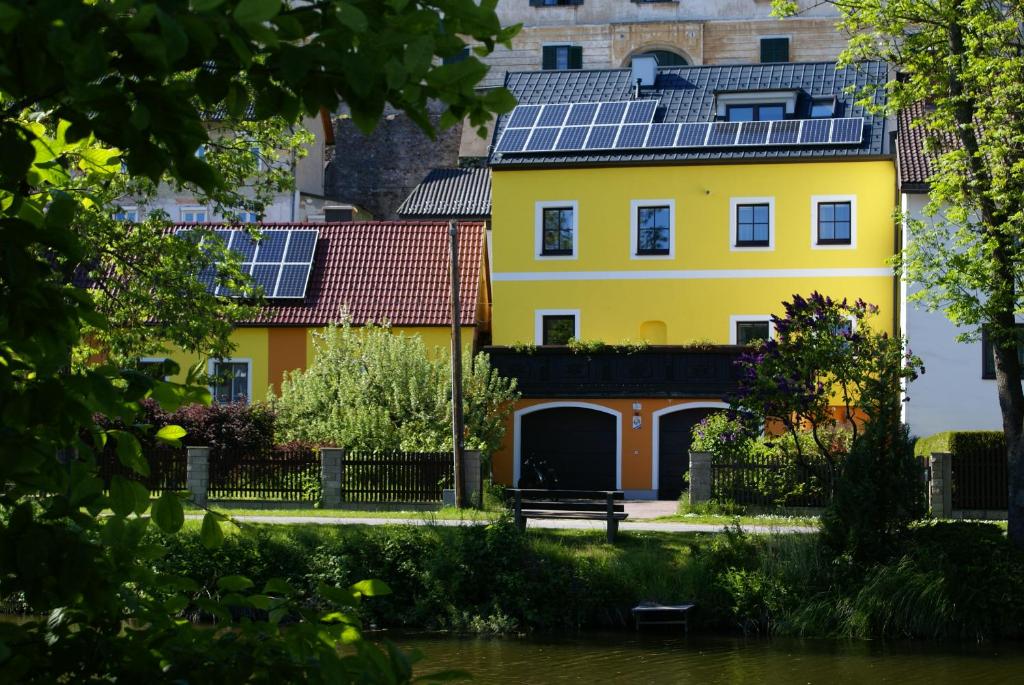 una casa gialla con pannelli solari sul tetto di Top Appartements Taufner a Waidhofen an der Thaya
