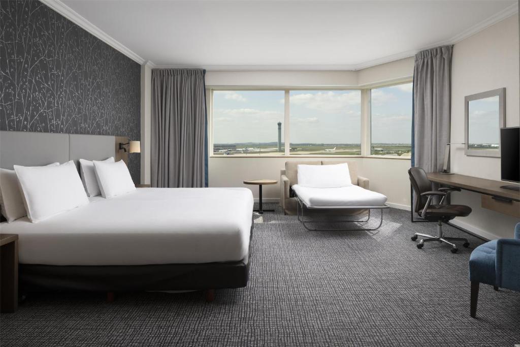 a hotel room with a bed and a desk at Hilton Paris Charles De Gaulle Airport in Roissy-en-France