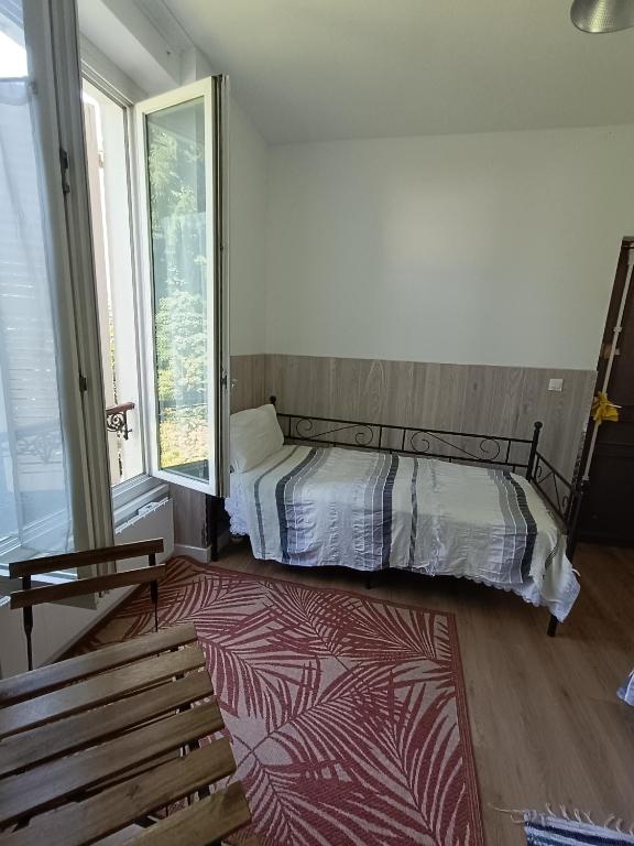 - une chambre avec un lit, un banc et une fenêtre dans l'établissement AcG, à Villeneuve-Saint-Georges