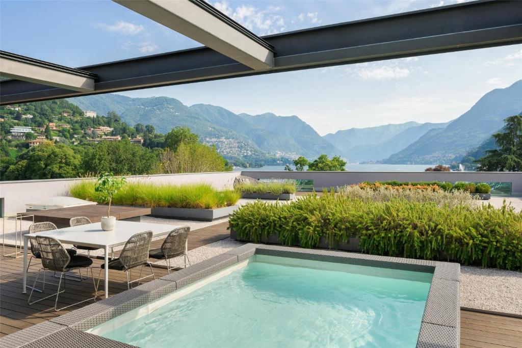 a swimming pool on the roof of a house with mountains at Hilton Lake Como in Como