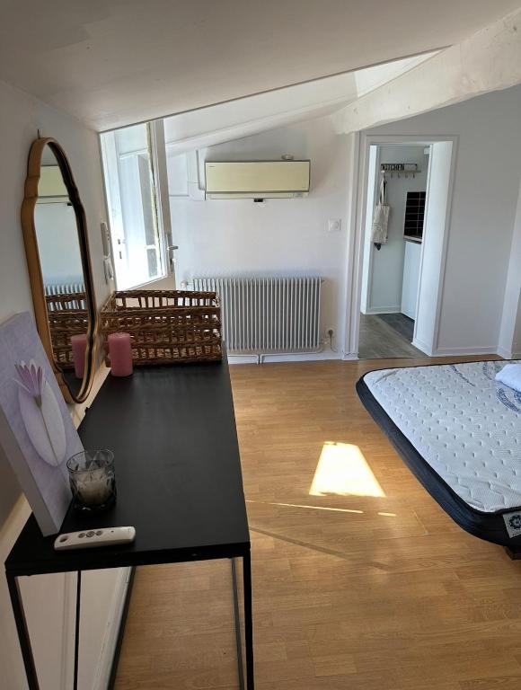 a room with a bed and a table with a mirror at Apartment with large terrace in Barrière de Toulouse in Talence