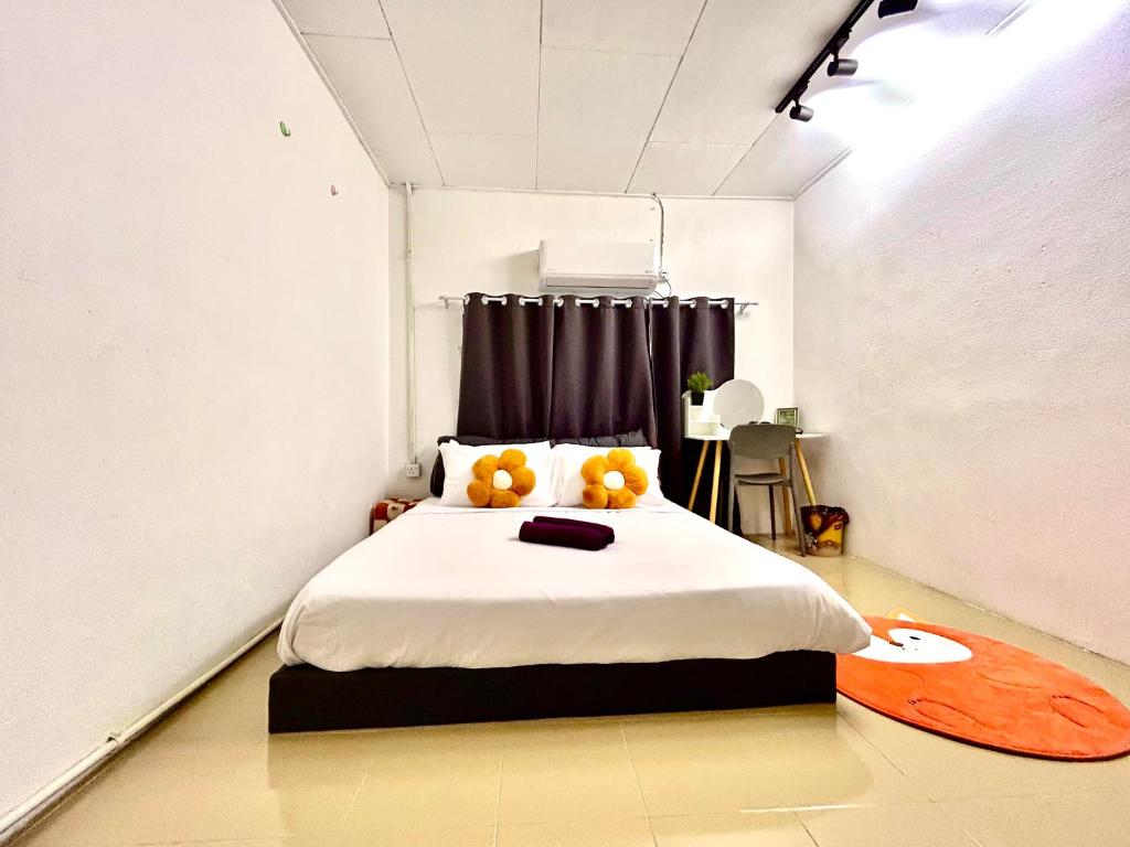 ein Schlafzimmer mit einem Bett mit zwei Orangen darauf in der Unterkunft Cozy39#6pax#netflix#jpnstyle#NearAlma#5kmtoIconCity#BM in Bukit Mertajam