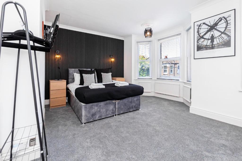 een slaapkamer met een bed en een klok aan de muur bij Modern 5-bed - Sleeps 10-walk To Centre & Parking! in Southampton