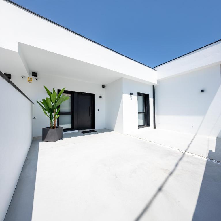 a white house with a potted plant on the roof at As Casas do Castro "Curota" in A Pobra do Caramiñal