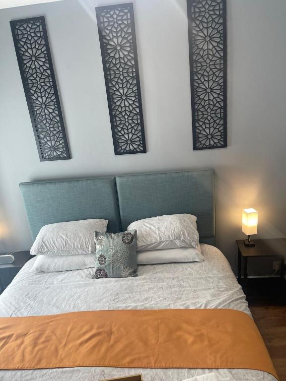 a bedroom with a bed with a blue headboard and pillows at The Westbank in Torquay