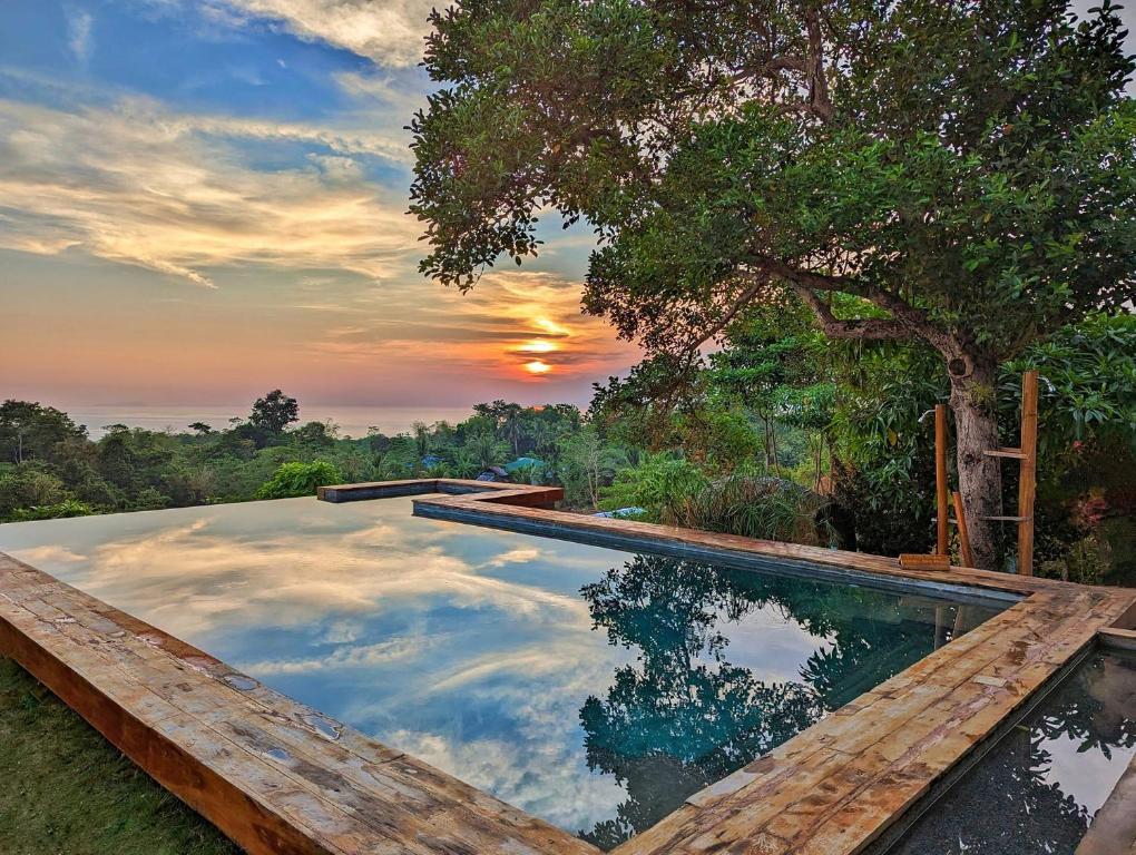 a swimming pool with a reflection of the sunset at Nakabalo Guesthouse & Restaurant in Siquijor