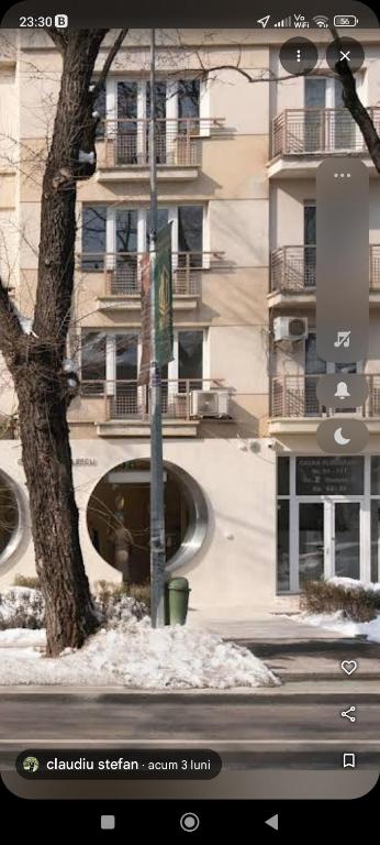a picture of a building with a tree and a street light at Floreasca apartment in Bucharest