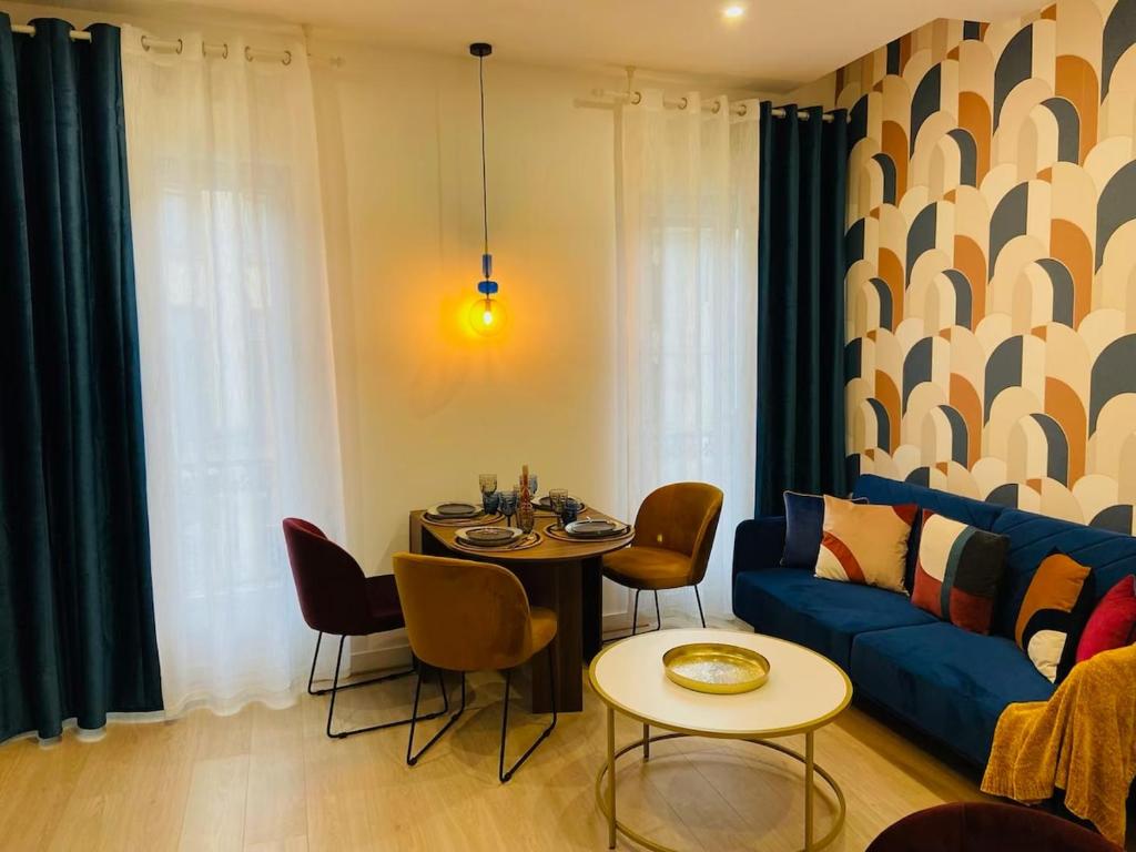 a living room with a table and a blue couch at Appartement hyper centre Balcon in Périgueux