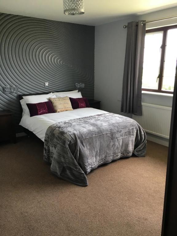 a bedroom with a large bed with a swirl pattern on the wall at Highgate Inn Hotel in Pembroke