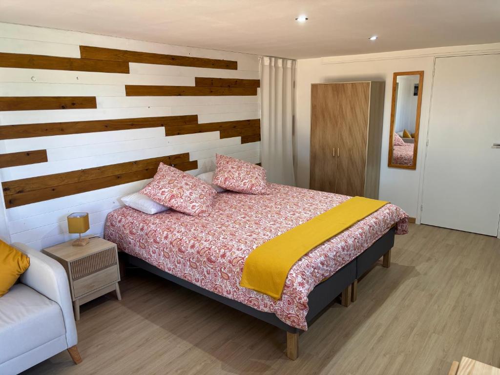 - une chambre avec un lit et un mur en bois dans l'établissement The Studio at Gites 474, à Sallèles-dʼAude
