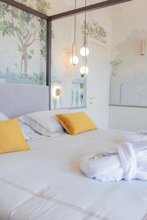 a bedroom with two beds with yellow pillows at Hotel Belvedere in Forte dei Marmi
