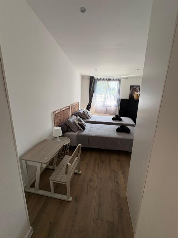 エマルグにあるMaison de standing proche de la merのベッドとテーブルと窓のある寝室