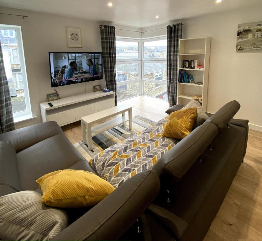 a living room with a couch and a tv at Lovely 1 bedroom flat in the heart of Newquay in Newquay